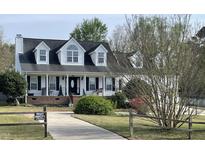 Charming two-story home with black shutters, white trim, and manicured lawn at 100 Blackberry Creek Dr, Willow Springs, NC 27592