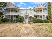 Charming brick townhouse with dual covered front porches and a welcoming walkway to the front door at 1115 Wake Forest Rd # B, Raleigh, NC 27604