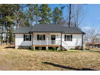 Charming home featuring a cozy front porch, dark shutters, and a well-maintained yard at 120 W College St, Oxford, NC 27565