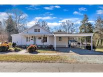 Charming single-story home with a covered porch and carport, set against a bright blue sky at 152 E Tryon St, Hillsborough, NC 27278