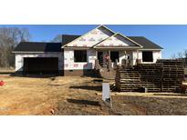 Under construction home featuring brick accents, a covered porch, and an attached two-car garage at 186 N Movado Trl, Kenly, NC 27542