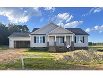 Charming single-story home featuring a covered front porch and attached two-car garage at 186 N Movado Trl, Kenly, NC 27542