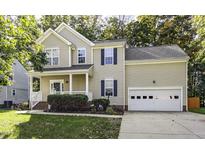 Charming two-story home features a welcoming porch, lush landscaping, and an attached two-car garage at 2208 Woodbury Dr, Hillsborough, NC 27278
