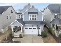 Charming two-story home with a covered front porch and attached two-car garage at 225 Ivy Arbor Way, Holly Springs, NC 27540