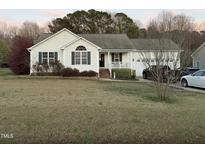 Charming single-story home featuring a well-maintained lawn, attached garage, and inviting front porch at 254 Pedernales Dr, Smithfield, NC 27577