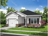 Charming single-story home with white siding, brick accents, landscaped yard and an attached garage at 303 E C St, Butner, NC 27509
