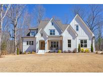 Beautiful two-story home boasting a crisp white exterior, well-manicured lawn, and a welcoming front porch at 3901 Laurel Creek Ln, Wake Forest, NC 27587
