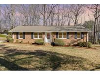 Charming single-story brick home featuring black shutters and a well-manicured front yard at 4508 Regis Ave, Durham, NC 27705