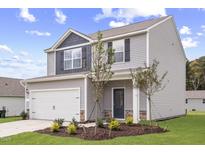 Charming two-story home with a light gray exterior, attached garage, and nicely landscaped front yard at 507 Benton Dr, Oxford, NC 27565