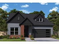 Charming home featuring a dark gray and red brick exterior, a modern garage door, and professionally landscaped front yard at 67 Wabash St, Pittsboro, NC 27312
