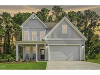Charming two-story home featuring a welcoming front porch and attached two-car garage at 69 White Azalea Way, Homesite 81, Benson, NC 27504