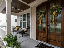 Charming front porch with seating and a beautifully decorated double-door entrance with seasonal wreaths at 730 Toms Creek Rd, Cary, NC 27519
