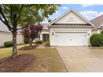Charming home exterior featuring a two-car garage, light siding, and well-manicured landscaping at 812 Gillinder Pl, Cary, NC 27519
