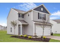 Charming two-story home with gray siding, attached garage, and a well-manicured front yard at 906 Rhino Bnd, Oxford, NC 27565