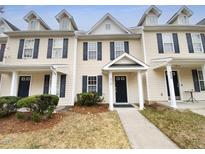 Inviting townhouse with blue shutters, a black door and small front yard at 910 Savin Lndg, Knightdale, NC 27545