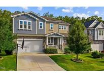 Charming two-story home with stone accents, a well-maintained lawn, and an attached two-car garage at 1025 Bender Ridge Dr, Morrisville, NC 27560