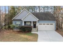Charming blue home with well-manicured landscaping and an attached two car garage at 105 Anderson Park Dr, Youngsville, NC 27596