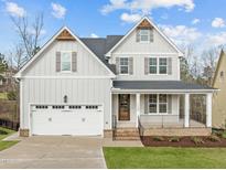 Charming two-story home features a welcoming front porch and a two-car garage at 112 Pointe Park Cir, Holly Springs, NC 27540