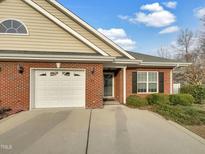 Charming single-story brick home with an attached garage and well-maintained landscaping at 12 Stonegate Dr, Angier, NC 27501