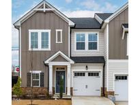 Charming two-story townhome with a well-manicured lawn, a blue front door and an attached garage at 1201 Canary Pepper Dr, Durham, NC 27713