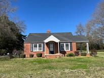 Charming one-story red brick home with a welcoming front porch and well-manicured lawn at 148 Baptist Church Rd, Henderson, NC 27537