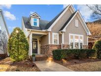 Charming home featuring stone accents, a welcoming front porch, and professionally landscaped yard at 1536 Crafton Way, Raleigh, NC 27607