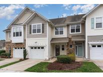 Charming townhome showcases a well-manicured lawn, attached garage, and inviting curb appeal at 2314 Wispy Green Ln, Raleigh, NC 27614