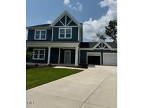 Charming two-story home with a two-car garage, concrete driveway, and beautiful green lawn at 321 Kavanaugh Rd, Wake Forest, NC 27587