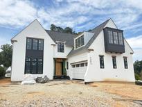 Stunning new construction home with a white facade, black windows, and modern architectural details at 3405 Makers Circle, Raleigh, NC 27612