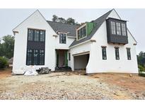 Striking new construction home featuring a white stucco exterior, black window frames, and a modern architectural design at 3405 Makers Circle, Raleigh, NC 27612