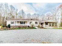 Charming single-story home with covered porch, carport and gravel driveway at 40 Ground Pine Ln, Siler City, NC 27344