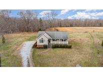 Charming home with a covered front porch and a long gravel driveway at 5001 W Pool Rd, Rougemont, NC 27572