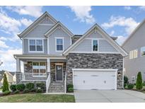 Beautiful two-story home featuring stone accents, a two-car garage, and a charming front porch at 5072 Aspen Meadow St, Raleigh, NC 27616