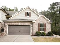 Charming brick home featuring a two-car garage, complemented by lush greenery and traditional shutters at 525 Rockcastle Dr, Cary, NC 27519