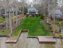 Lake house with a well-kept lawn that slopes down to the water and a dock at 651 Sagamore Dr, Louisburg, NC 27549