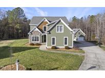 Charming two-story home with green siding, stone accents, and a well-manicured lawn at 1001 Hazeltown Rd, Wake Forest, NC 27587