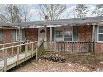 Exterior brick home featuring a front porch and wooden ramp at 1066 Shuford Rd, Wake Forest, NC 27587