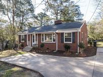 Charming brick home featuring black shutters, a concrete driveway, and well-maintained landscaping at 1106 Northview St, Garner, NC 27529