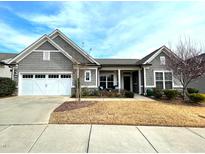Charming gray home with a well-manicured lawn, attached garage, and a welcoming front porch at 1108 Mendocino St, Wake Forest, NC 27587