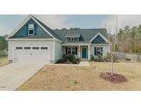 Charming home featuring a two-car garage, beautiful blue accents, and a well-maintained lawn at 129 Edgefield Dr, Sanford, NC 27332