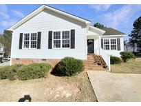 Charming single-story home with white siding, black shutters, and landscaped front yard at 13 Herndon Ct, Clayton, NC 27520