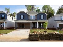 Two-story home with blue and gray siding, brick-lined garage, and newly installed sod at 165 Klamath Dr, Garner, NC 27529