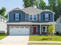Two-story home featuring a brick-accented facade, attached two-car garage and well-manicured front lawn at 165 Klamath Dr, Garner, NC 27529