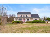 Charming two-story home featuring a welcoming front porch with white railings and a well-maintained lawn at 170 Blande Dr, Kenly, NC 27542