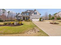 Charming two-story home with a manicured lawn, lovely landscaping, and an attached two-car garage at 1726 River Club Way, Franklinton, NC 27525
