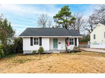 Charming one-story home with white siding, black shutters, and a neatly maintained front yard at 1817 Rankin St, Raleigh, NC 27604