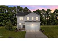 Charming two-story home with a well-manicured lawn and a spacious two car garage at 20 Diamond Creek Dr, Zebulon, NC 27597