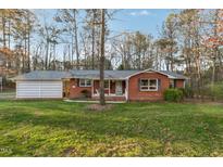 Charming red brick home with a well-manicured lawn and mature trees at 209 High House Rd, Cary, NC 27513