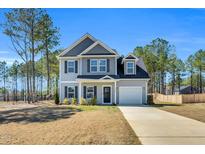 Charming two-story home features a gray exterior, black shutters, attached garage and a well-manicured front lawn at 286 Beacon Hill Rd, Lillington, NC 27546