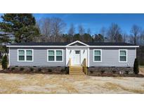 Charming single-story home with gray siding, white trim, and a inviting front entry way at 321 Duke Memorial Road, Louisburg, NC 27549